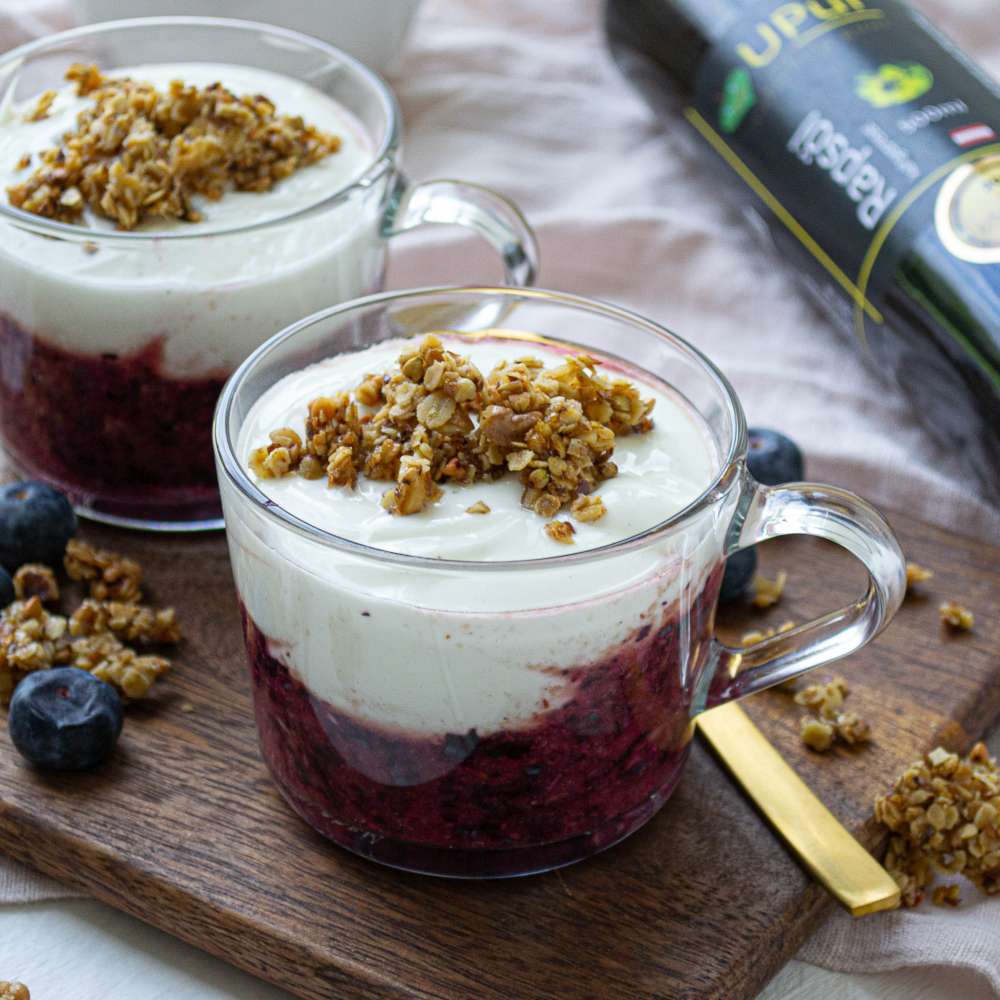 Selbstgemachte JoghurtSelbstgemachtes Heidelbeer-Joghurt mit Granola aus regionalen Zutatencreme mit Granola aus regionalen Zutaten